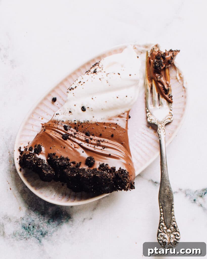 Effortless Chocolate Silk Tart 3 A perfect slice of no-bake chocolate tart on a white plate, showcasing its rich layers.