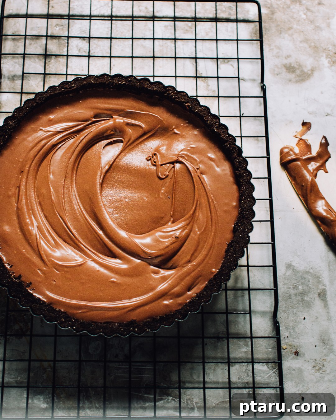 Effortless Chocolate Silk Tart 5 A close-up of a no-bake chocolate tart with a knife showing the smooth ganache texture.