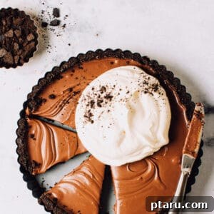 A chocolate tart cut into slices, ready to be served.