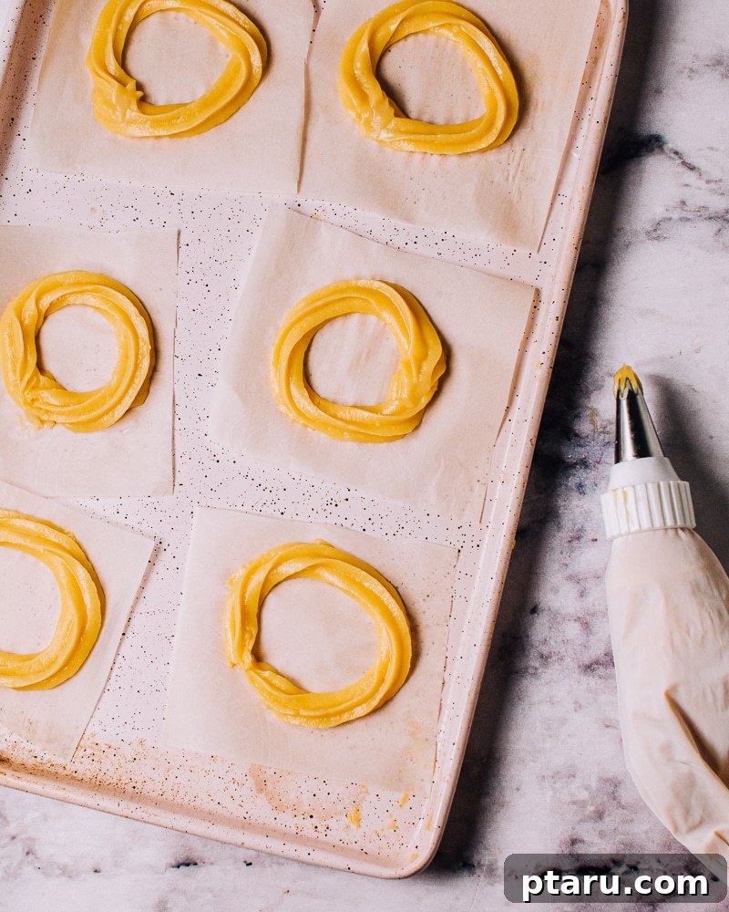 Airy French Doughnuts 13 Piping French cruller dough into rings on parchment paper squares