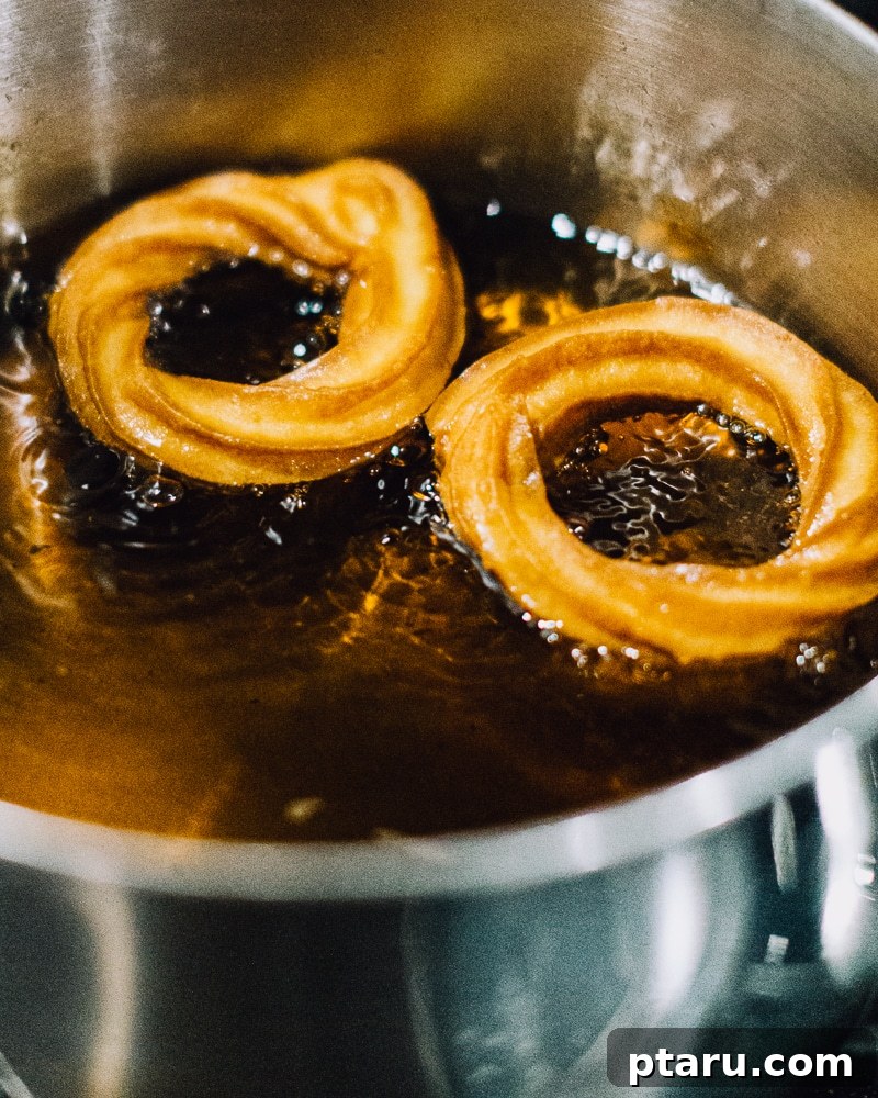Airy French Doughnuts 14 Frying French crullers in hot oil, carefully removing parchment paper