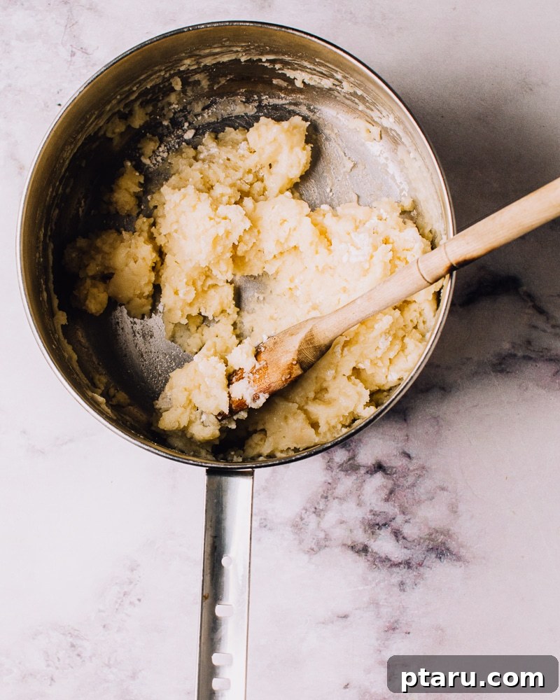 Airy French Doughnuts 7 Stirring choux pastry dough in a saucepan to form a cohesive ball