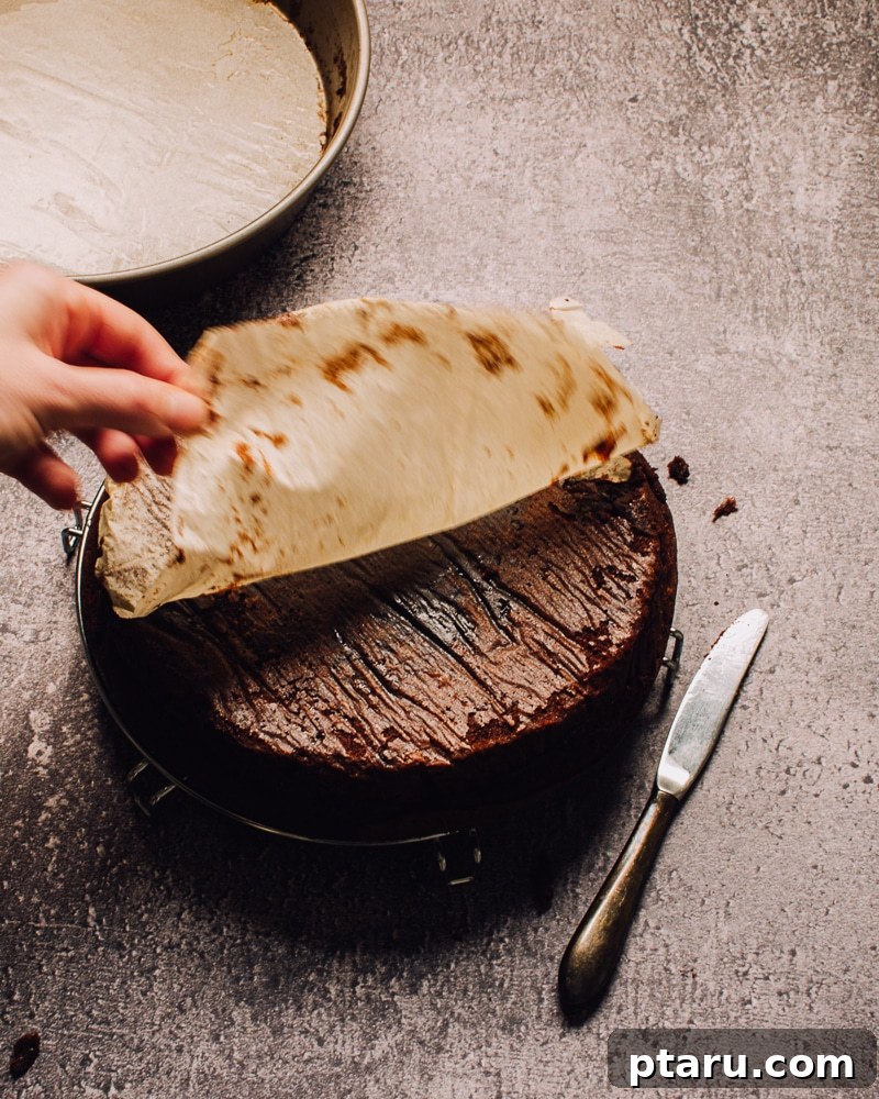 Velvet Chocolate Cloud 9 Flourless Chocolate Cake carefully inverted onto a wire rack, with parchment paper removed.