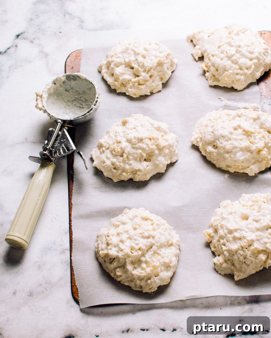 Cloud-Like Buttermilk Drop Biscuits 5 Freshly baked buttermilk drop biscuits, golden and inviting, stacked on a cooling rack.