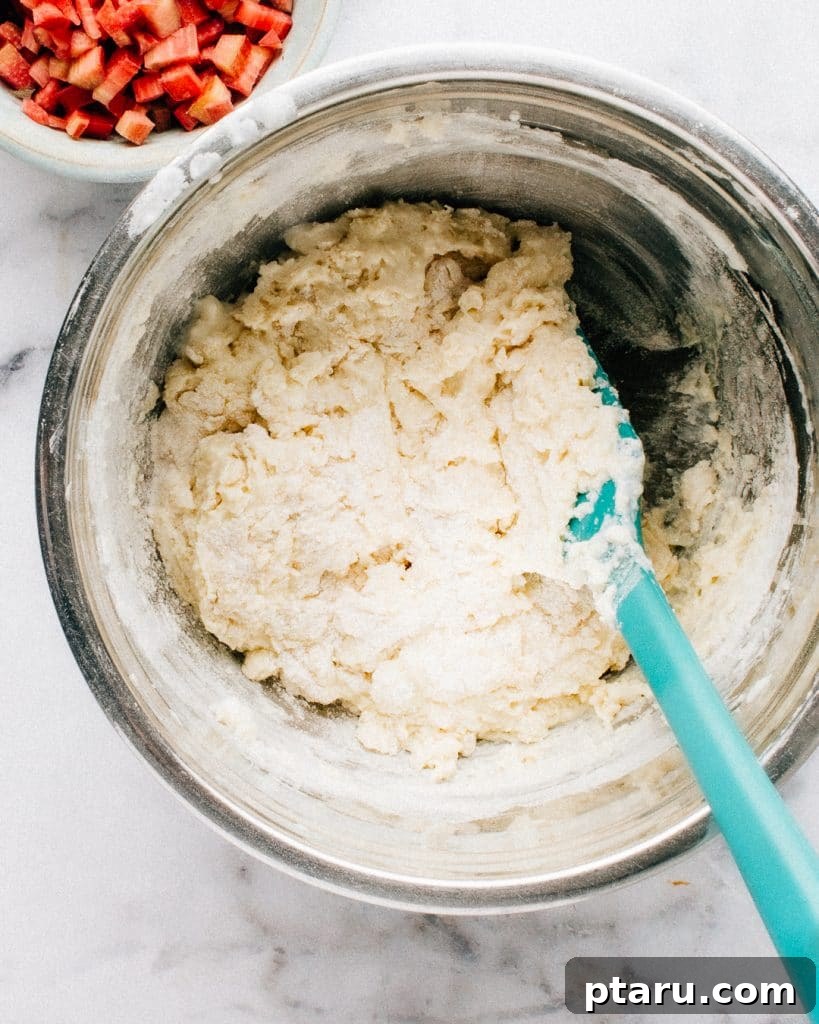 Wholesome Rhubarb Greek Yogurt Muffins 4 Mixing rhubarb muffin batter in a bowl.