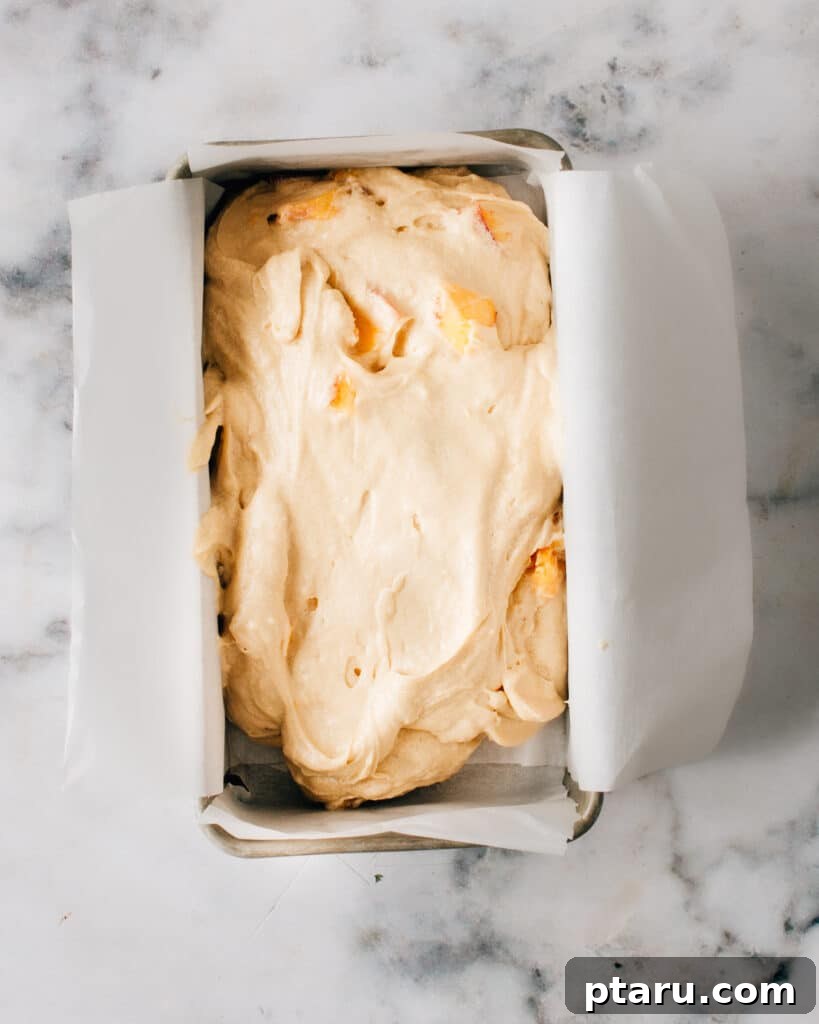 Grandma's Peach Cobbler Pound Cake 8 Peach pound cake batter being poured into a loaf pan before baking