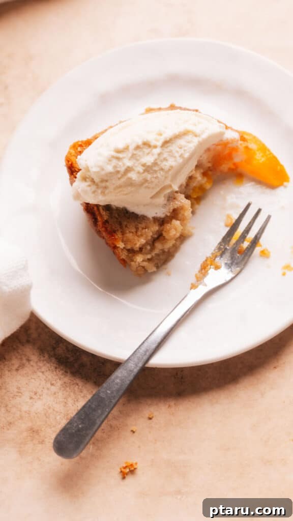 Grandma's Peach Cobbler Pound Cake 9 A slice of Peach Cobbler Pound Cake with vanilla ice cream on a plate