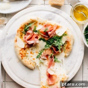 Prosciutto Pizza with Arugula is super easy to whip up, with olive oil and garlic in lieu of a sauce. It is layered with texture and flavour.