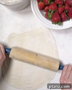 Roll out puff pastry dough into a rough circle.