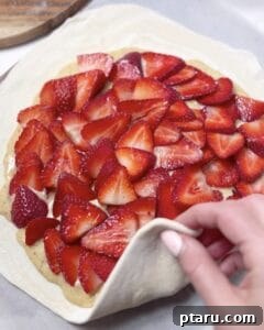 Fold puff pastry edges over strawberry and almond cream filling.