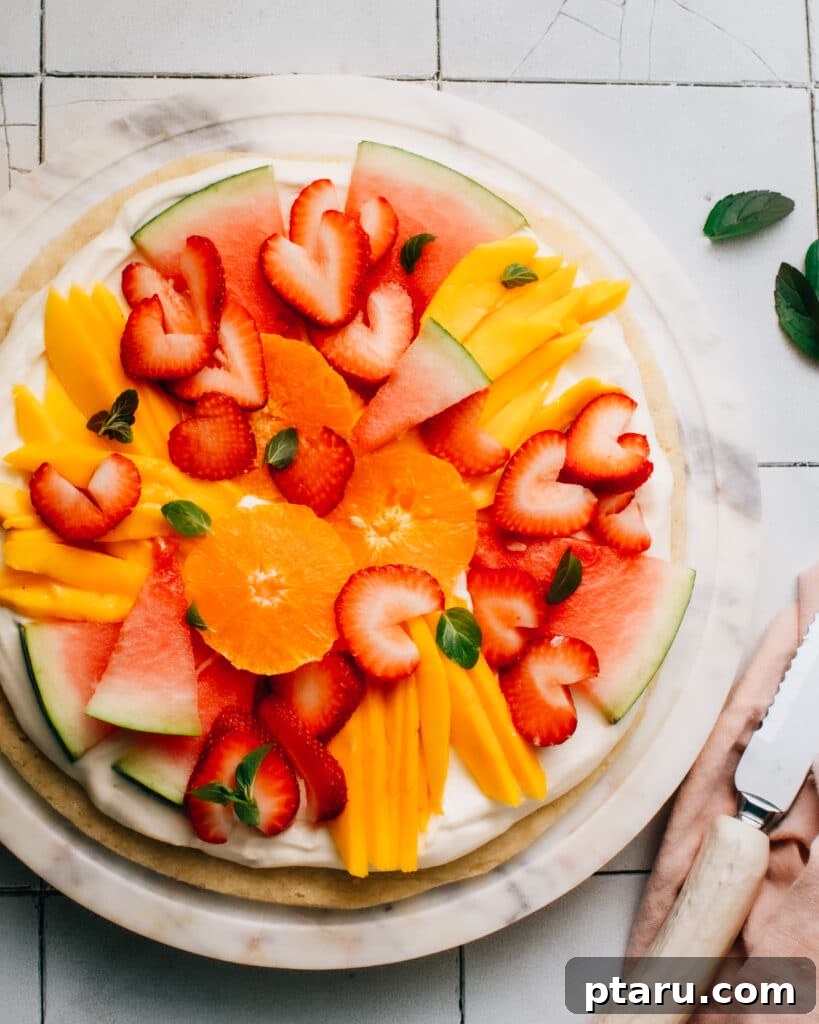 Ultimate Fruit Pizza: Cookie Crust Bliss, Cream Cheese Cloud 3 Close-up of a vibrant fruit pizza showcasing a variety of fresh berries and kiwi slices on a creamy frosting over a sugar cookie crust.