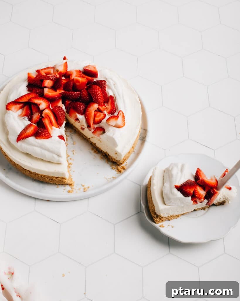 Effortless Cloud Cheesecake 2 A perfectly sliced No Bake Cheesecake topped with fresh berries, showcasing its fluffy texture and golden graham cracker crust.