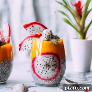 A vibrant, layered mango chia pudding with fresh fruit toppings in a glass jar.