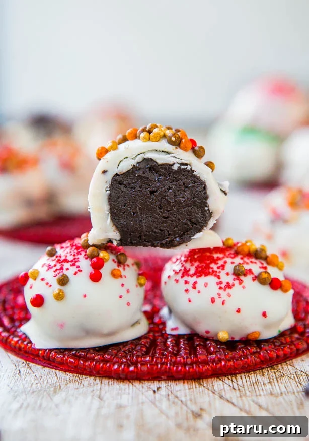 Effortless Festive Bites: 15+ No-Bake Christmas Sweets 16 3 No-bake Oreo Truffle balls with one cut open to show the chocolate filling.