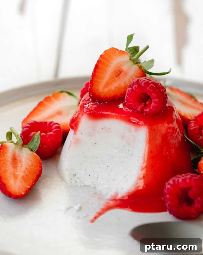 15 Irresistible Italian Desserts to Sweeten Your Christmas 14 A close-up of beautifully presented Italian Panna Cotta, topped with vibrant strawberry coulis and fresh strawberries, highlighting its smooth, creamy texture and elegant appeal.