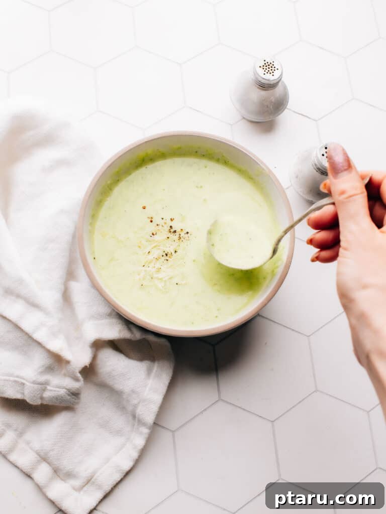 Silky Zucchini Potato Velouté 2 A beautifully presented bowl of creamy potato zucchini soup, garnished with fresh herbs and a swirl of cream, inviting a comforting meal.