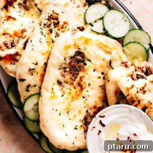 A perfectly cooked Keema Naan, golden brown and slightly puffed, showing a hint of the delicious filling.