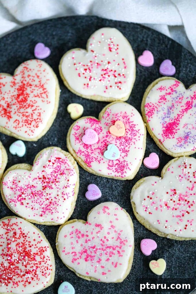 Love at First Bite: Simple Valentine's Sugar Cookies 12 Classic Valentine sugar cookies elegantly decorated with sprinkles and small heart candies, making them perfect for gifting.