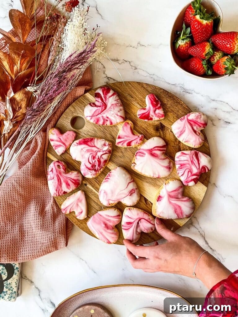 Love at First Bite: Simple Valentine's Sugar Cookies 5 Exquisite marbled sugar cookies shaped like hearts, artfully arranged on a round kitchen board, ready for a Valentine's celebration.