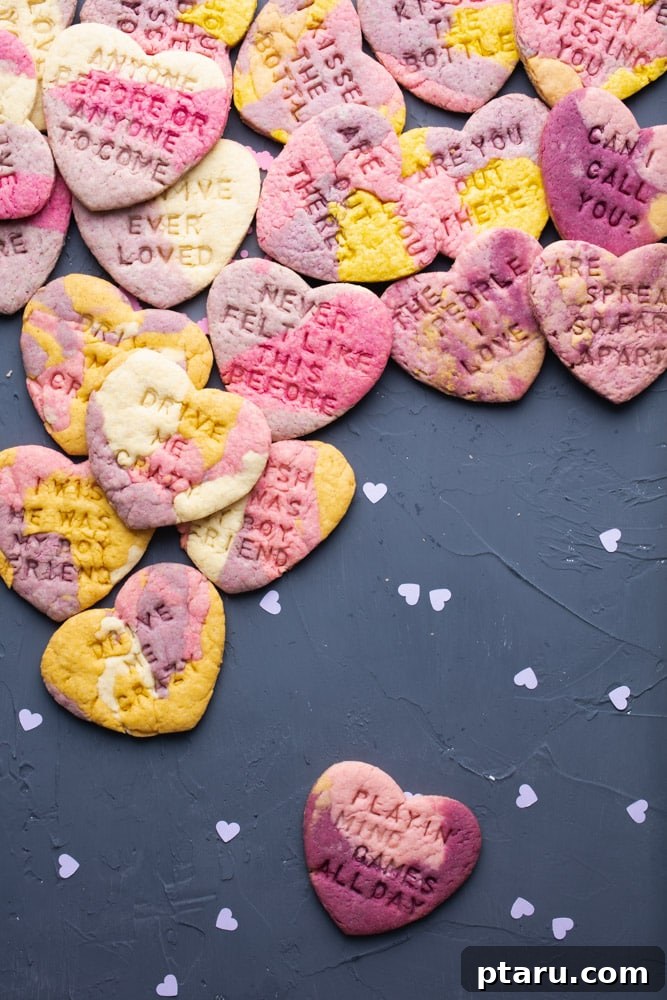 Love at First Bite: Simple Valentine's Sugar Cookies 9 Stack of beautifully decorated Valentine's Day conversation sugar cookies with marbled icing and stamped messages.