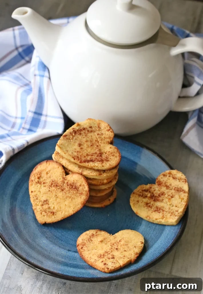 Love at First Bite: Simple Valentine's Sugar Cookies 10 Warm and inviting cinnamon sugar cookies made with coconut flour, stacked neatly on a plate with a teapot for a cozy Valentine's treat.
