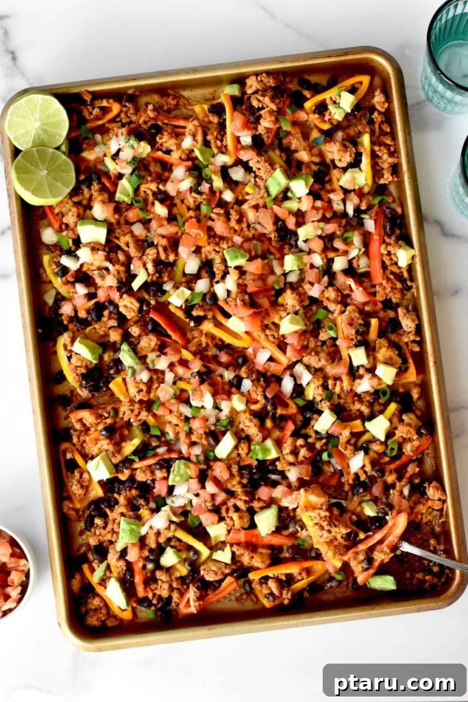 Epic Game Day Nachos: 15 Simple Recipes for Your Crowd 11 A top-down view of crunchy mini pepper nachos spread out on a baking sheet, featuring colorful peppers, melted cheese, and fresh garnishes.