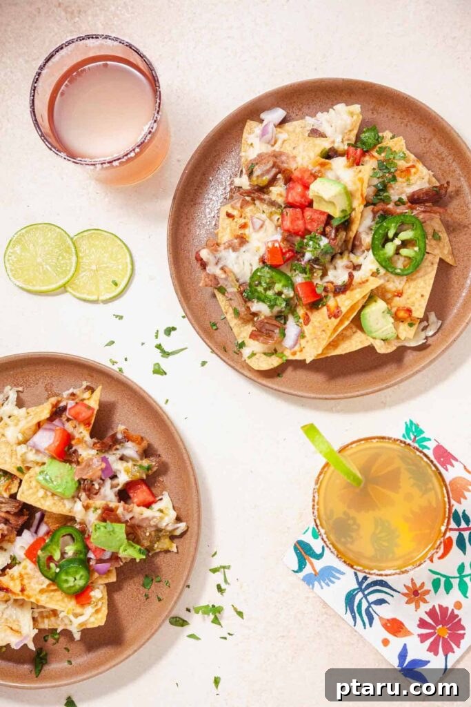 Epic Game Day Nachos: 15 Simple Recipes for Your Crowd 12 A vibrant plate of Carnitas Nachos, generously loaded with toppings, served alongside a refreshing drink.