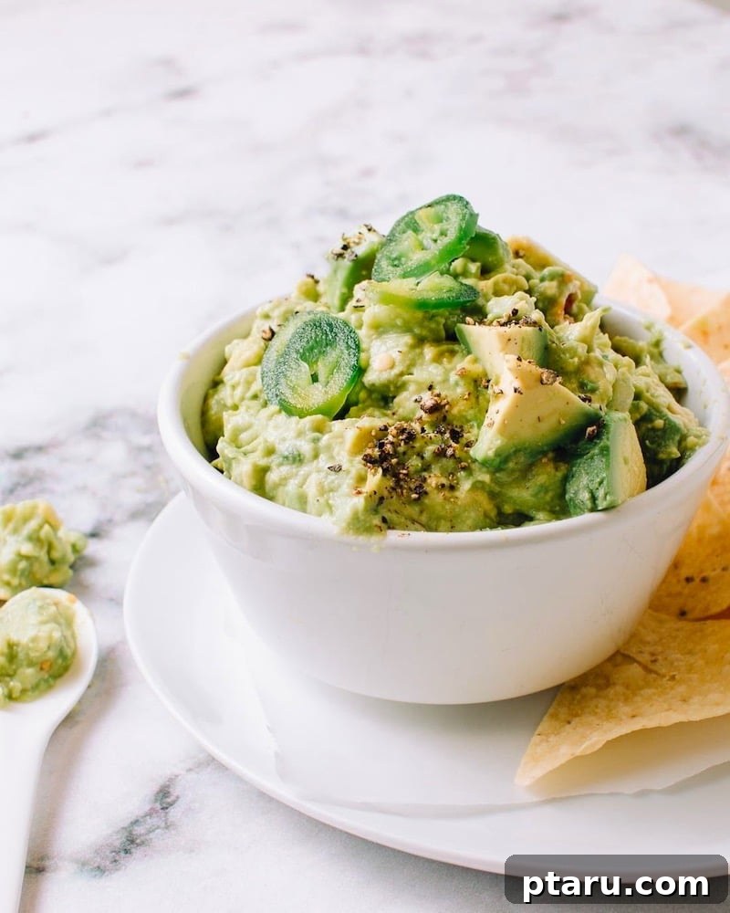 Epic Game Day Nachos: 15 Simple Recipes for Your Crowd 17 A beautifully textured bowl of homemade guacamole, garnished with fresh cilantro, ready to be enjoyed.