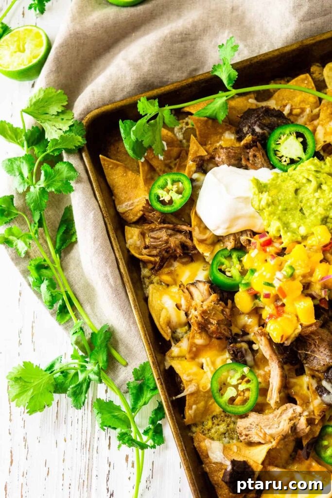 Epic Game Day Nachos: 15 Simple Recipes for Your Crowd 5 Delicious Sheet Pan Jerk Pork Nachos with melted cheese, vibrant tropical toppings, and fresh cilantro.