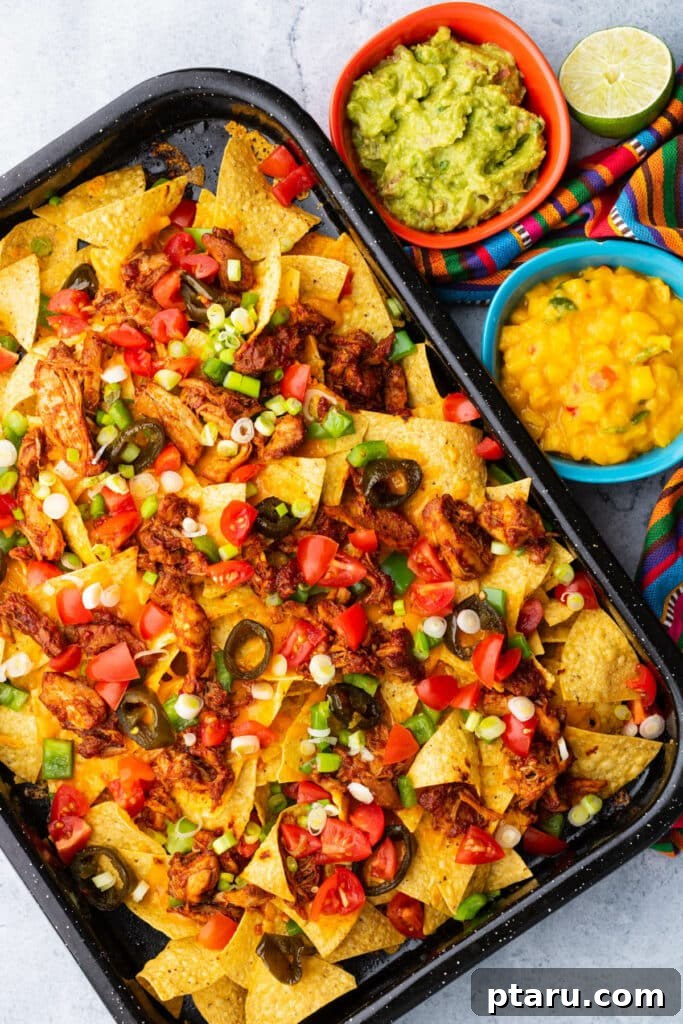 Epic Game Day Nachos: 15 Simple Recipes for Your Crowd 7 A top-down view of vibrant BBQ chicken nachos, richly topped with melted cheese, jalapeños, and fresh salsa, ready to be devoured.