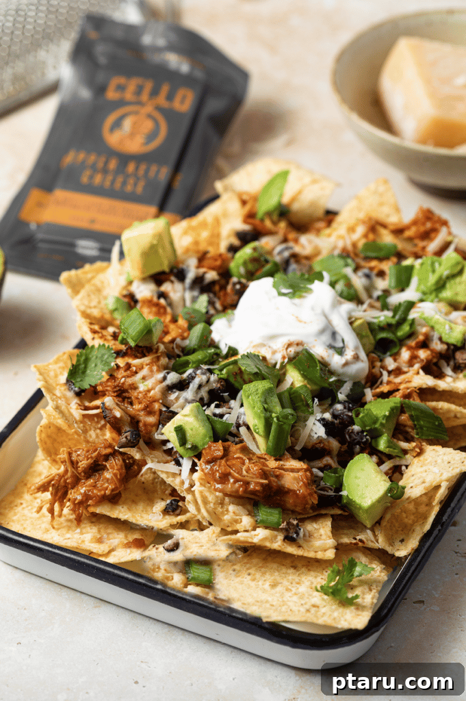 Epic Game Day Nachos: 15 Simple Recipes for Your Crowd 8 Crispy air fryer nachos piled high in a bowl, showcasing their golden-brown chips and melted cheese from a side view.