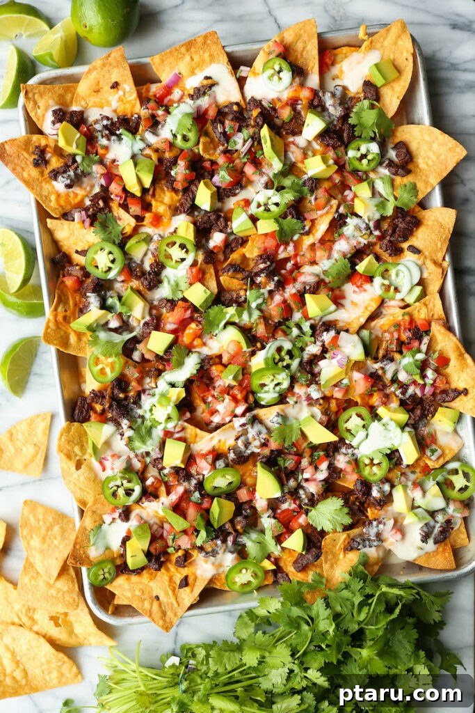 Epic Game Day Nachos: 15 Simple Recipes for Your Crowd 10 Loaded carne asada nachos beautifully arranged on a sheet pan, showcasing the vibrant colors and generous toppings.
