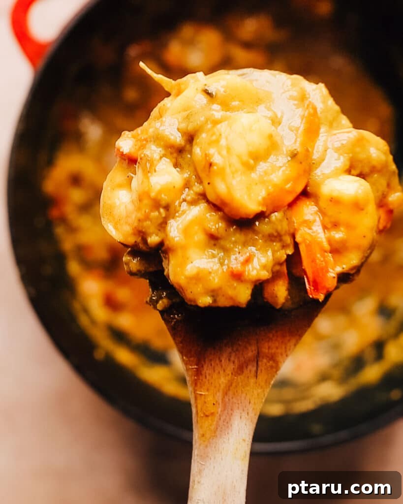 Island Soul Shrimp Curry 7 A spoonful of rich, creamy Jamaican Curry Shrimp, showcasing the tender shrimp and vibrant sauce, ready to be eaten.