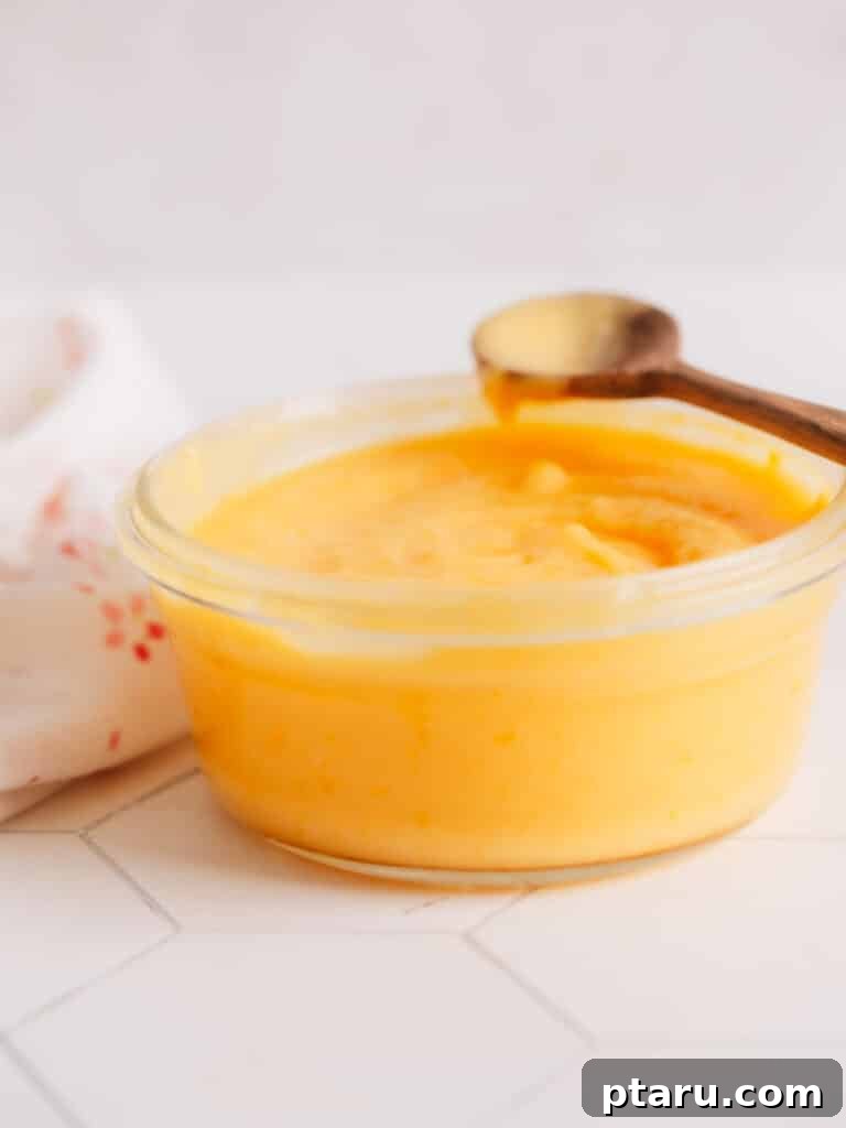 Tangy Lemon Curd Delights 4 A bowl filled with rich, creamy homemade lemon curd, ready to be used as a luscious filling for lemon curd cookies.