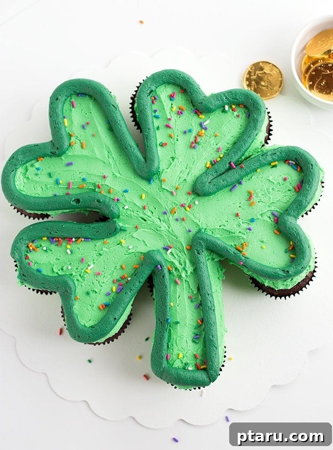 Get Lucky with These Green St. Patrick's Day Desserts 11 A vibrant St. Patrick's Day Cupcake Cake artfully arranged in the shape of a four-leaf clover, each cupcake adorned with green frosting and festive sprinkles, ready to be pulled apart and enjoyed.