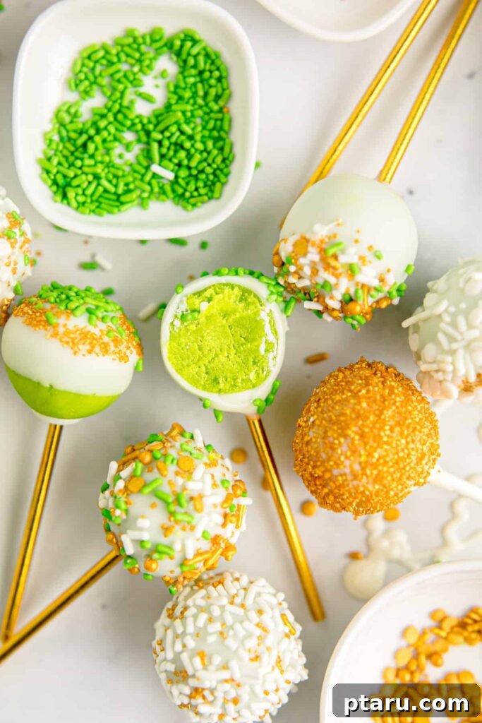 Get Lucky with These Green St. Patrick's Day Desserts 8 A cluster of vibrant green cake pops stands upright on golden sticks, each generously coated in white chocolate and adorned with an assortment of festive green sprinkles, creating an inviting and celebratory display.