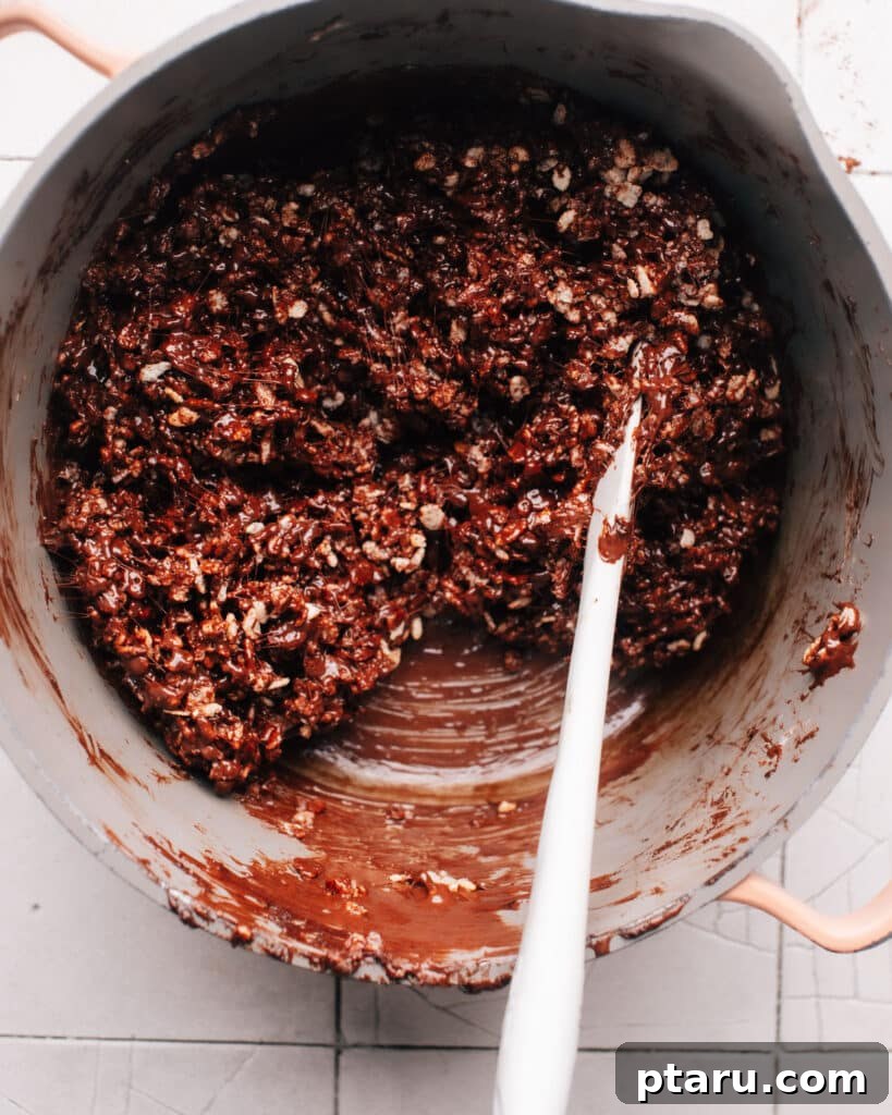 Decadent Chocolate Crunch Bars 8 A saucepan filled with melted marshmallows, chocolate chips, and rice krispie cereal mixture ready to be poured into a baking sheet.