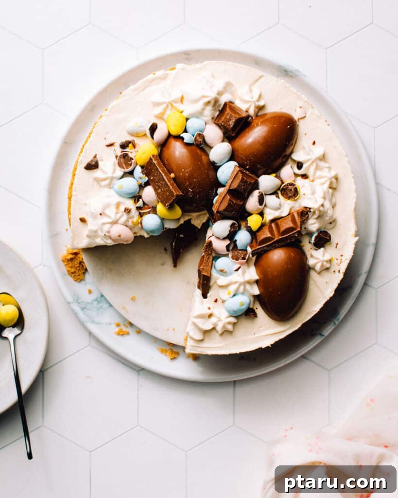 Festive No-Bake Easter Egg Cheesecake 2 A beautifully decorated No-Bake Easter Egg Cheesecake, adorned with colorful chocolate Easter eggs, presented on a large serving plate. A slice has been removed, revealing the velvety smooth, creamy interior and the perfectly set graham cracker crust. This festive dessert promises to be a highlight of any spring or Easter gathering.