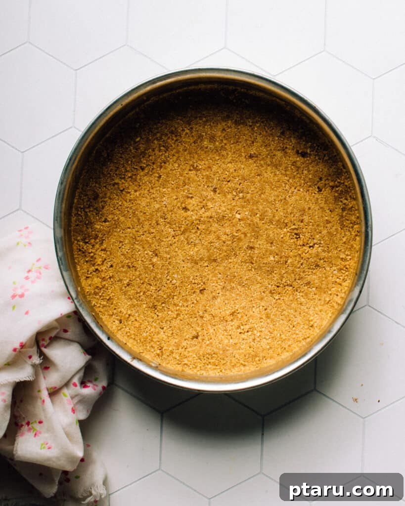 Festive No-Bake Easter Egg Cheesecake 5 The bottom of a 9-inch springform pan, showing a perfectly pressed graham cracker crust. The crust is evenly distributed and packed firmly up the sides, creating a solid and appealing base for the no-bake Easter egg cheesecake.