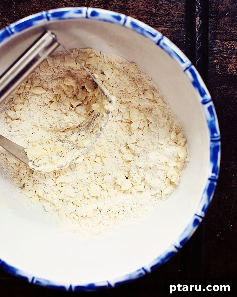 Skip the Rolling Pin: Easiest Press-In Butter Pie Crust 4 A freshly made, unbaked no-roll pie crust in a metal pie dish, with a perfectly pressed edge.