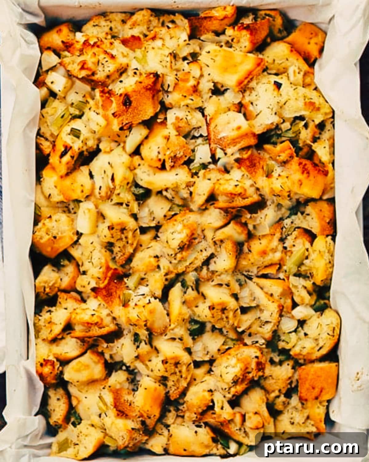 Baked Apple and Sage Stuffing 2 Golden-brown turkey stuffing with apples and herbs, ready to be served on a Thanksgiving table.