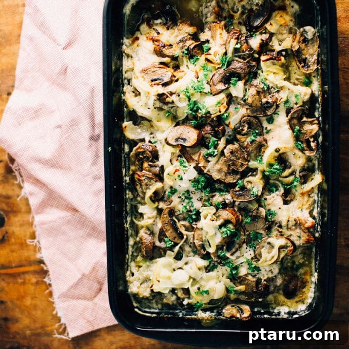 Oven Smothered Pork Chops with Caramelized Onions and Mushrooms 3 Close-up of a serving of smothered pork chops with creamy mushroom gravy and fresh parsley