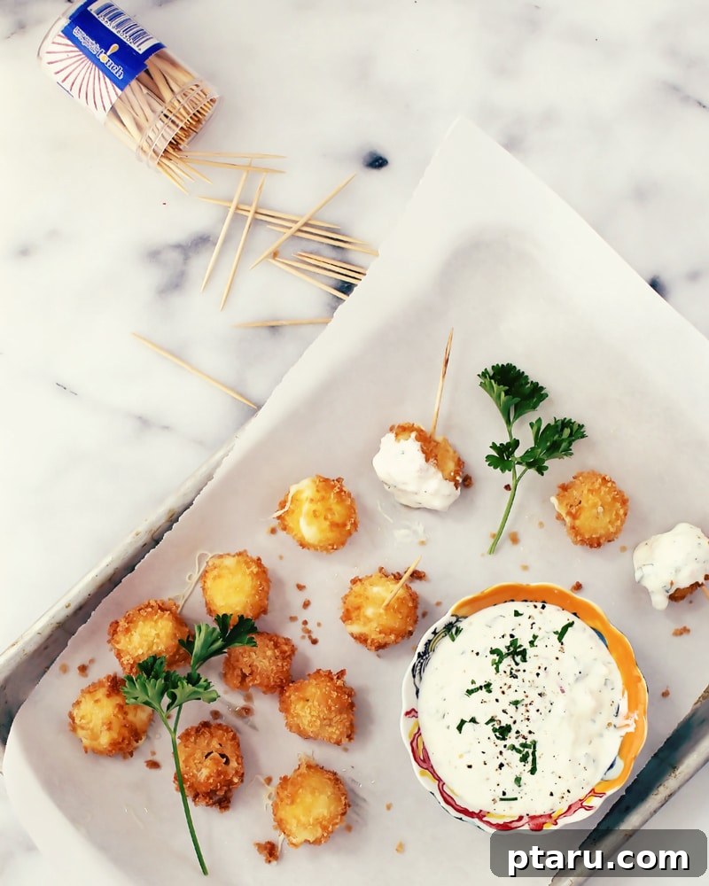 Bite-sized Mozzarella Delight with Jalapeno Ranch Zing 4 A close-up of bocconcini mozzarella balls coated in panko breadcrumbs, ready for frying.