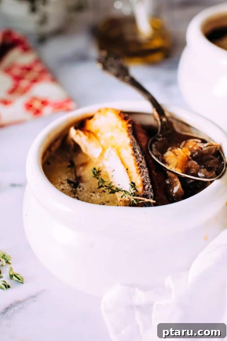 Golden Brie Crowned French Onion Soup 6 A beautifully presented bowl of French Onion Soup with a perfect brie crouton, photographed from above, highlighting its rich texture and inviting steam.