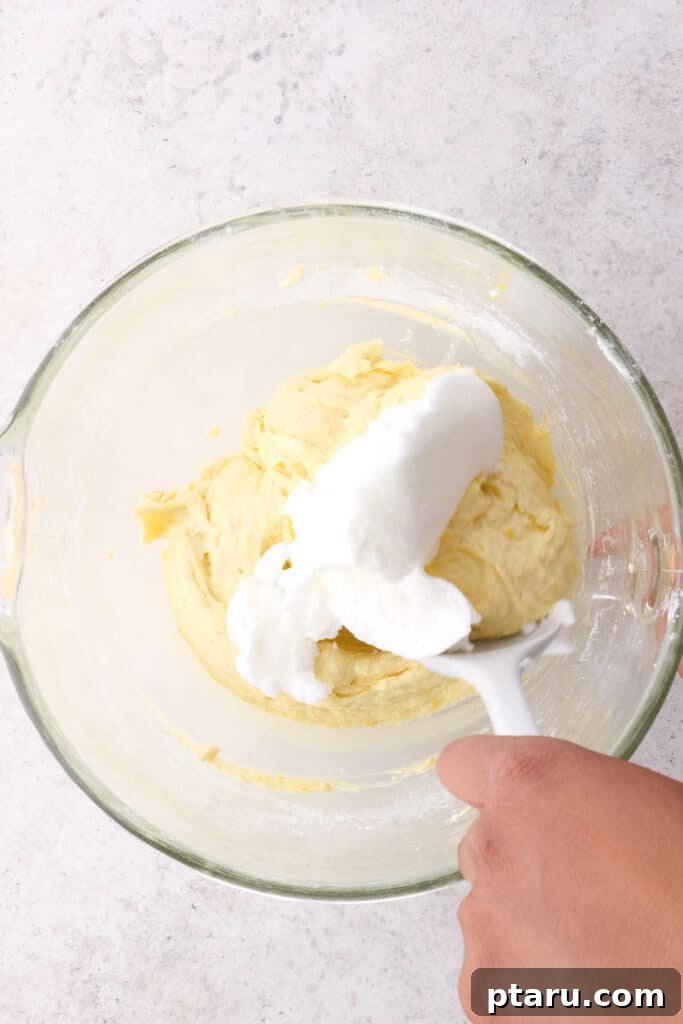 Folding Egg Whites Step 3: Folding egg whites gently into the orange cake batter.