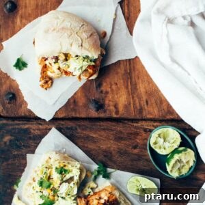 Blackened Fish Sandwiches with Spicy Corn and Cabbage Slaw on a plate with lime wedges.