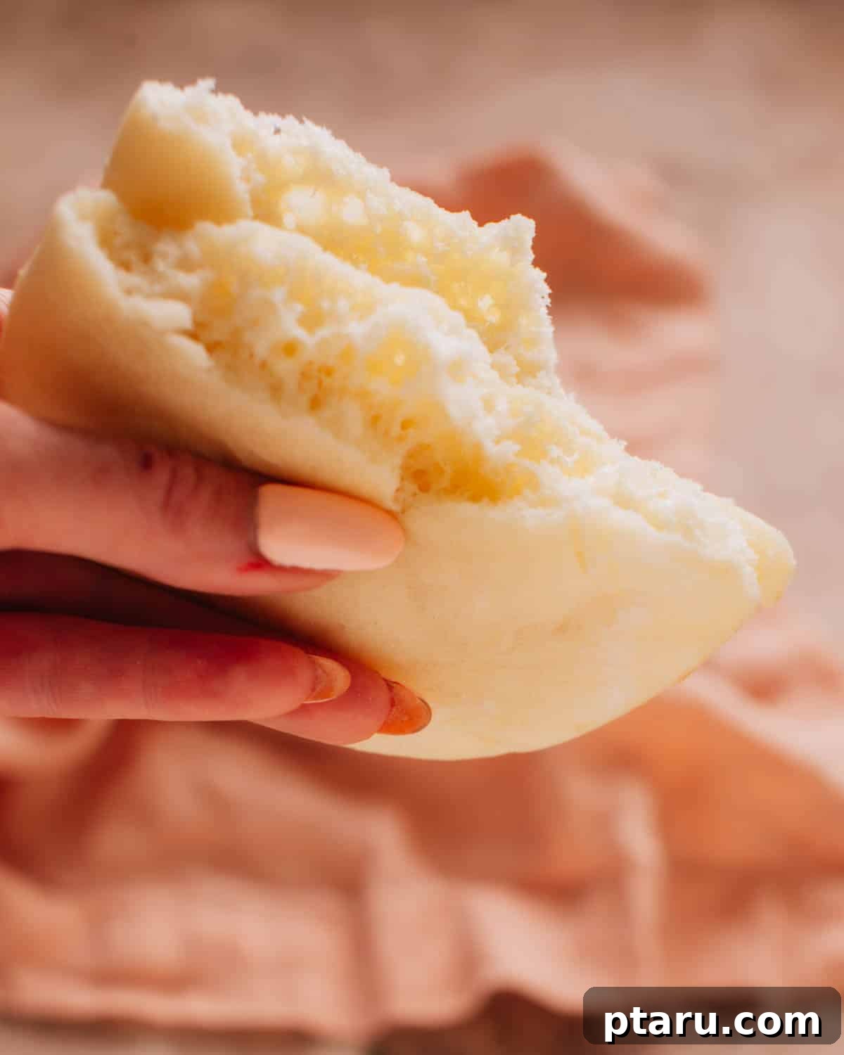 Silky Simit Delights 3 Hand holding a half of Turkish bread (bazlama) to reveal its fluffy and soft interior.