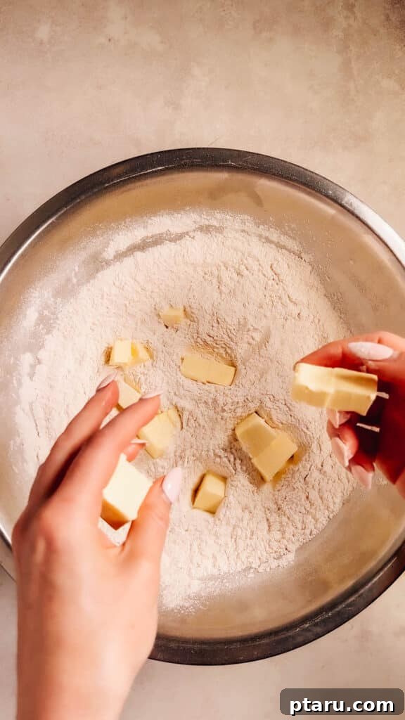 Simple Hand-Mixed Pie Crust 5 Adding the first portion of cold butter, cut into cubes, to the flour mixture.