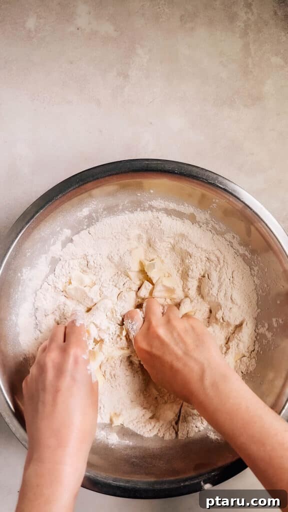 Simple Hand-Mixed Pie Crust 6 Hands demonstrating how to rub butter into flour until it resembles damp breadcrumbs.