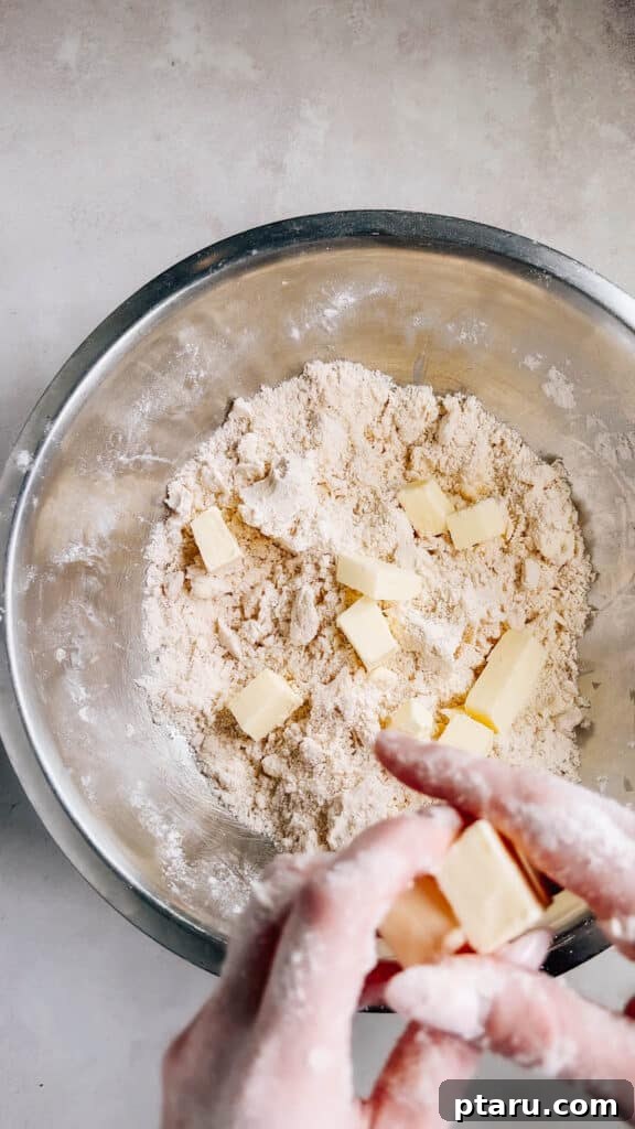 Simple Hand-Mixed Pie Crust 8 Adding the second portion of butter, leaving visible chunks, to the flour mixture.